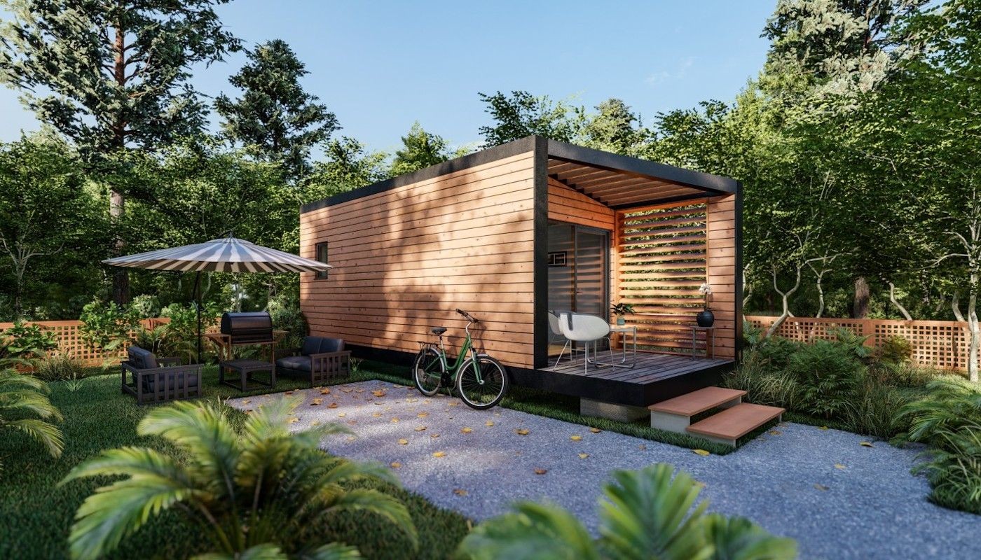 Modern wooden tiny house in a lush garden with outdoor seating and a bicycle.