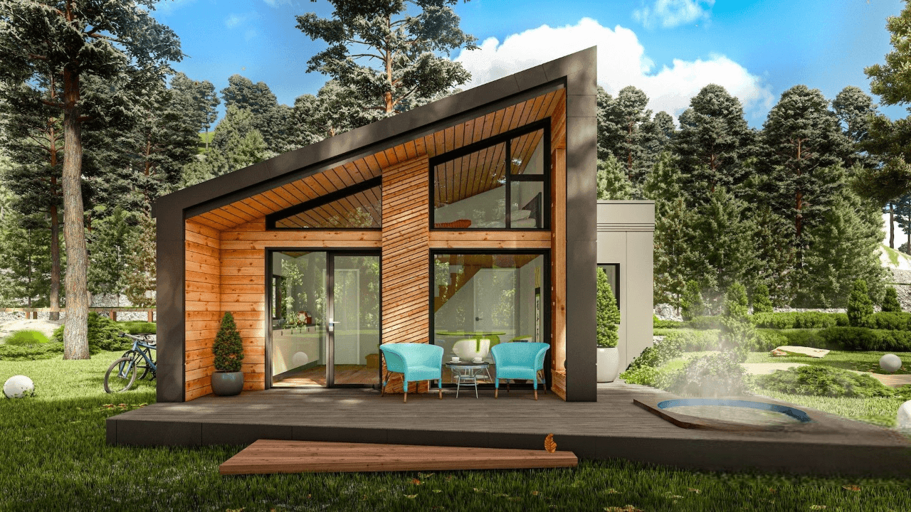 Modern wooden house with angled roof, patio, and blue chairs in a forest setting.