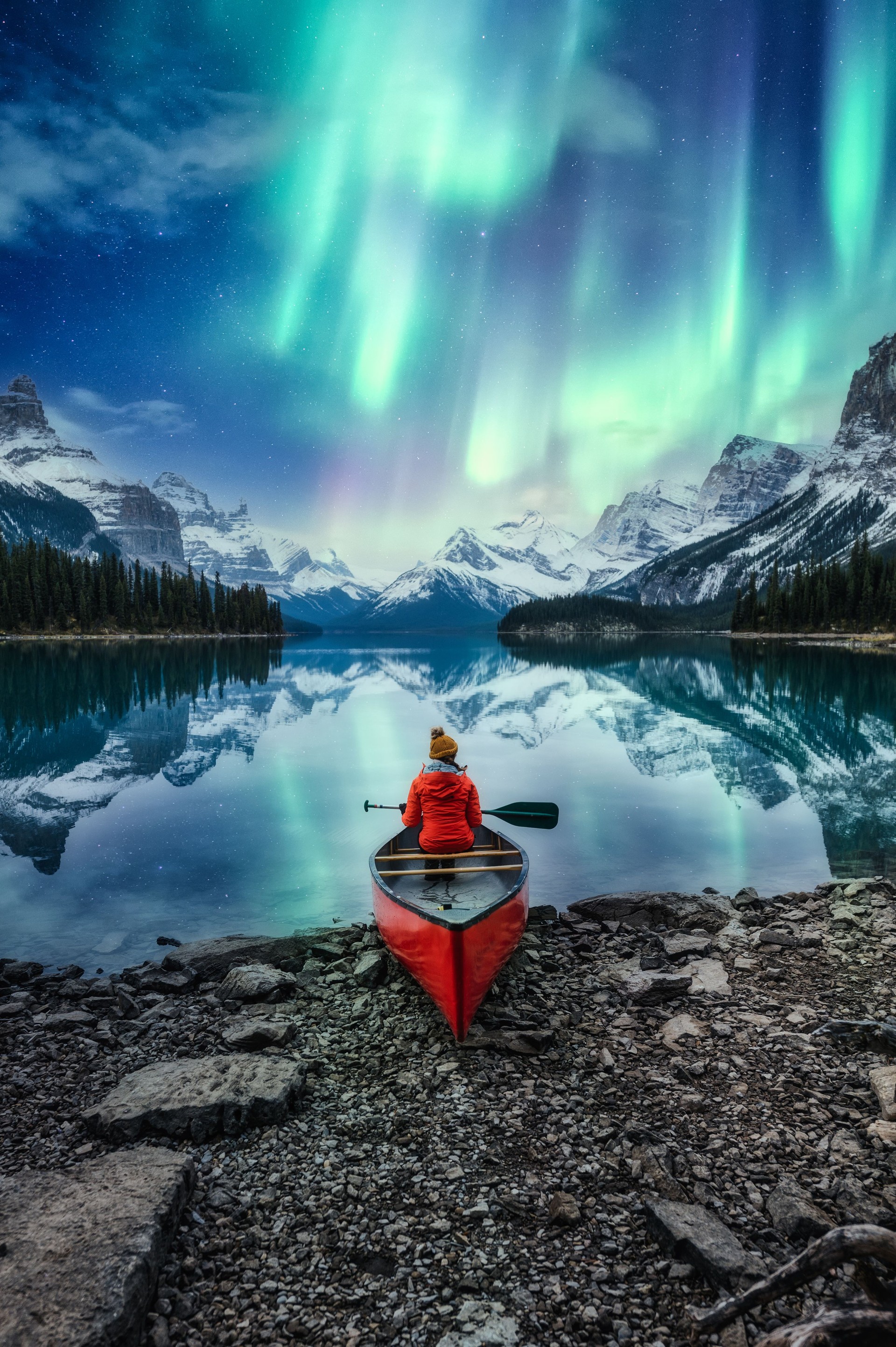 Magnifiques aurores boréales sur l’île de l’esprit avec une voyageuse en canoë au parc national Jasper